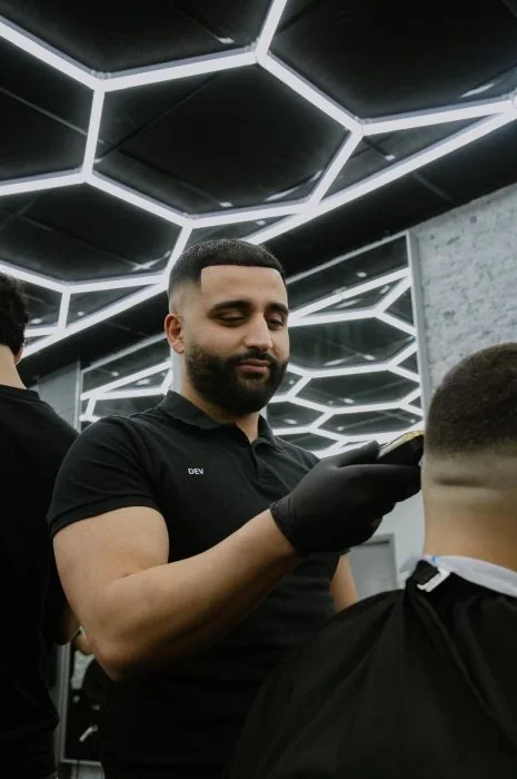 Dev knipt een klant in zijn barbershop